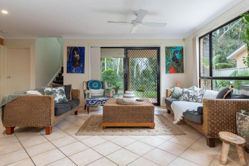 a living room with couches and a table at 21 Cedar Grove in Forster