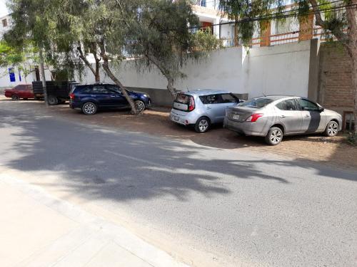 a row of parked cars parked next to a wall at Montemar Apart Hotel - Playa Huanchaco in Huanchaco