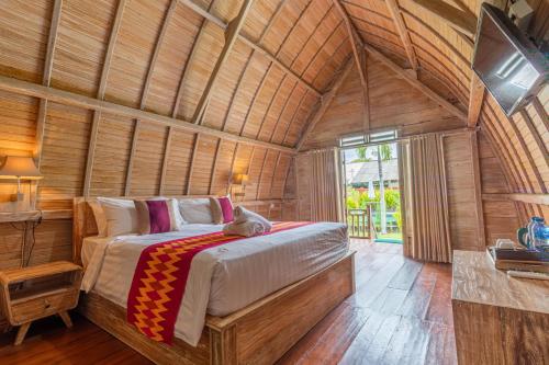 sypialnia z łóżkiem w drewnianym pokoju w obiekcie Daghan Cottage Nusa Penida w mieście Nusa Penida