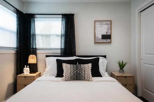 Schlafzimmer mit einem großen weißen Bett und schwarzen Vorhängen in der Unterkunft Luxurious House, 25 min Downtown, 10min Midway in Burbank