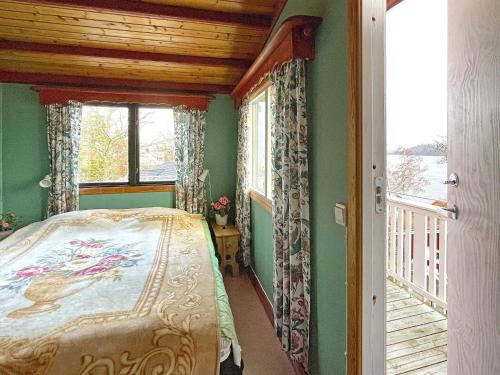 een slaapkamer met een bed en een balkon met een raam bij Holiday home Uddevalla XXIII in Uddevalla