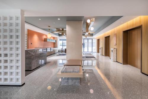 a lobby of a building with a fountain at Guangzhou Baiyun Airport MeHood Liz Hotel Free Shuttle Bus to Canton Fair and to Airport in Guangzhou