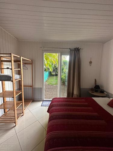 Schlafzimmer mit einem Bett und einer Glasschiebetür in der Unterkunft B&B Tontouta in La Tontouta