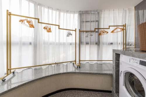 a laundry room with a washer and dryer at Guangzhou Baiyun Airport MeHood Liz Hotel Free Shuttle Bus to Canton Fair and to Airport in Guangzhou
