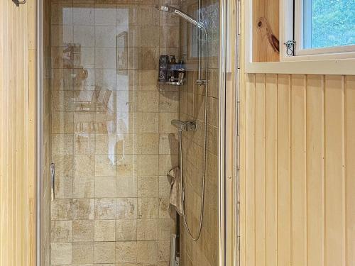 La salle de bains est pourvue d'une douche avec une porte en verre. dans l'établissement Holiday home NYNÄSHAMN, à Nynäshamn