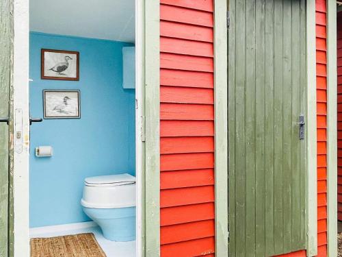 a bathroom with a toilet and a red and blue wall at Holiday home AXVALL in Axvall