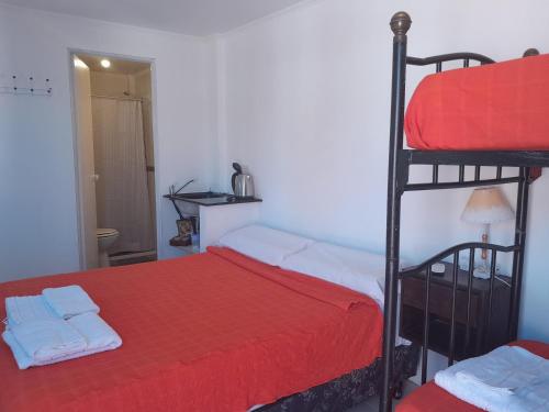 een slaapkamer met 2 stapelbedden en een rode deken bij Matices in Gualeguaychú