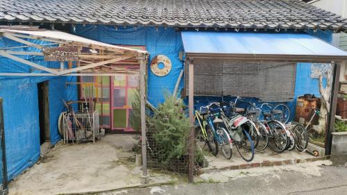 Gegege no Guesthouse - Vacation STAY 9461 في Uozu: مبنى أزرق مع دراجات متوقفة خارجه