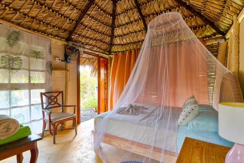 a bedroom with a bed with a mosquito net at GuaiGüí Bayahibe in Bayahibe