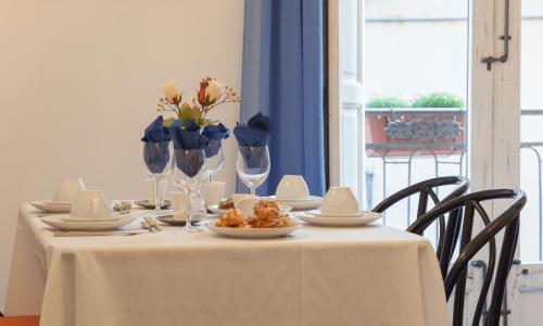 a table with a white table cloth and flowers on it at B&B Dimora di Girgenti in Agrigento
