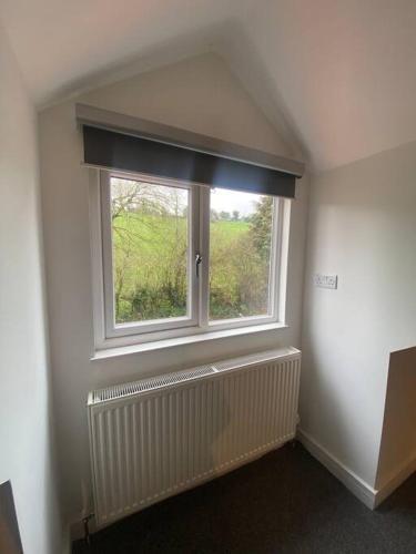 a room with a window with a radiator and a window blind at 17A Stella house nr Bath in Radstock