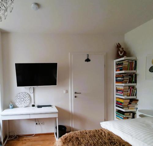 a bedroom with a desk with a television on a wall at Augarten Apartment in Graz