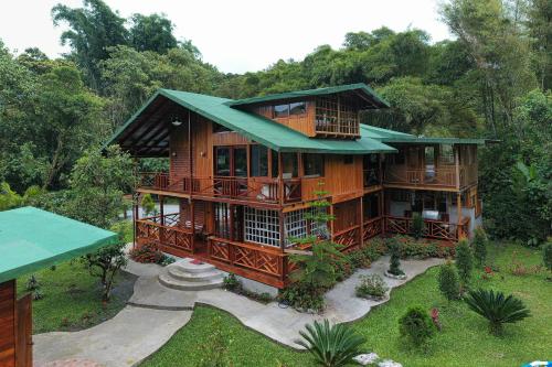 a large wooden house with a green roof at The Wooden House Mindo in Mindo