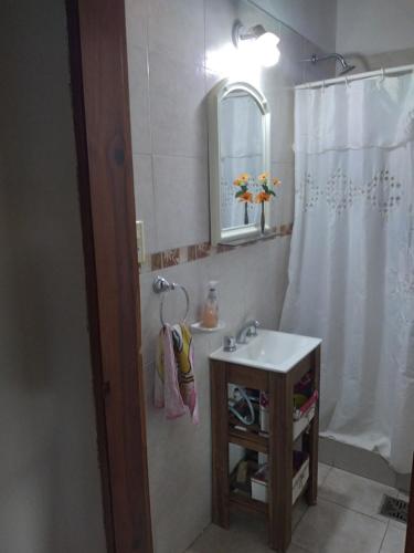 y baño con lavabo y ducha con espejo. en El Country en Gualeguay