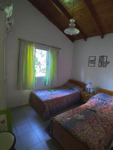 1 dormitorio con 2 camas y ventana en El Country en Gualeguay