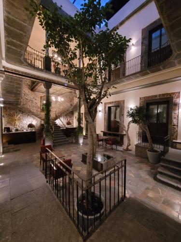 普埃布拉的住宿－Milo Collection Hotel，一座庭院,楼里有一棵树