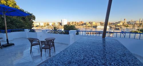 a balcony with two chairs and a table and an umbrella at La Terrace in Aswan