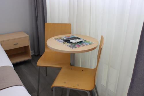 a small table and a chair in a room at Caloundra Central Apartment Hotel Official in Caloundra