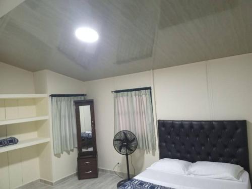 een slaapkamer met een groot bed en een ventilator bij CABAÑA 6 in Pereira