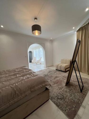 een slaapkamer met een bed en een bank erin bij Luxury villa Near The Beach in Temara