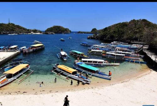 a group of boats in the water at a beach at Hundred Islands lucky One Transient 3mins walk fr wharf in Alaminos