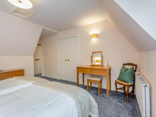 Kiltarlty的住宿－Cruives Lodge，一间卧室配有一张床、一张桌子和一把椅子