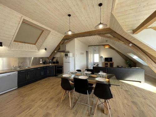 une cuisine avec une table et des chaises dans une pièce dans l'établissement Gîte en pleine nature avec clim, terrasse et wifi - FR-1-489-441, à Saint-Léon