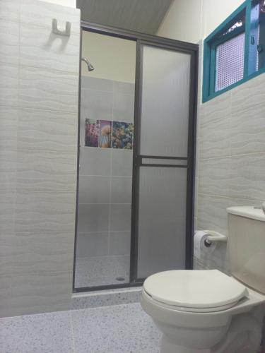 een badkamer met een toilet en een glazen douche bij CABAÑA 6 in Pereira