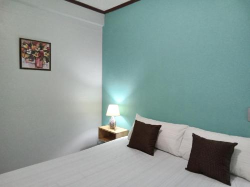 sypialnia z białym łóżkiem i niebieską ścianą w obiekcie The Couples Inn w mieście Montego Bay