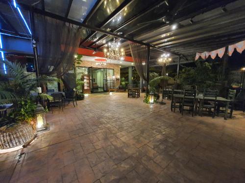 Cute Hotel & Dorms Ipoh في ايبوه: مطعم مع فناء مع طاولات وكراسي
