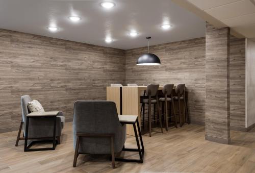 a waiting room with a row of chairs and a bar at Candlewood Suites Lafayette - River Ranch by IHG in Lafayette