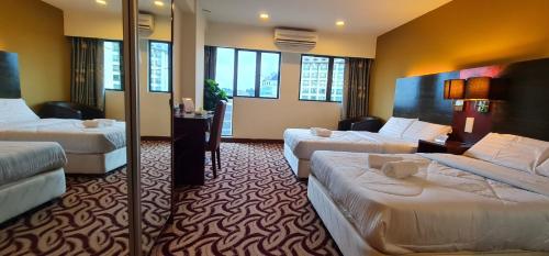 una habitación de hotel con 2 camas y una habitación con ventanas en BV1 STUDIO KK CITY CENTRE WITH POOL NEAR Imago, en Kota Kinabalu