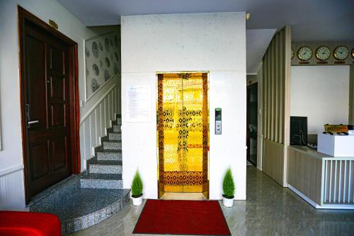 a hallway with a door and stairs with a red rug at TTR Vincent Hotel in Da Lat