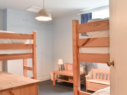 a bedroom with two bunk beds and a table at Black Bank House in Studdon
