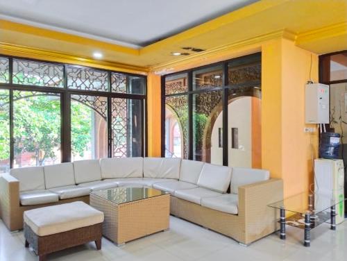 a living room with a white couch and some windows at ISLAMIC GUEST HOUSE AT TAQWA in Cirebon