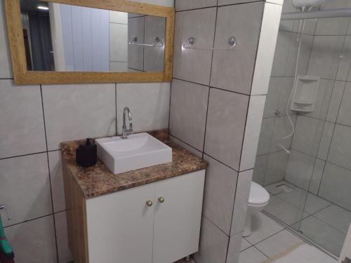 W łazience znajduje się umywalka, toaleta i lustro. w obiekcie Chalé D´Roos III w mieście Canela