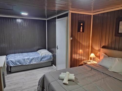 Chalé D´Roos III في كانيلا: غرفة نوم عليها سرير وفوط