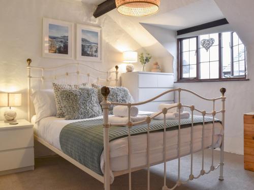 a bedroom with a white bed and a window at Ivory Cottage in Woolacombe
