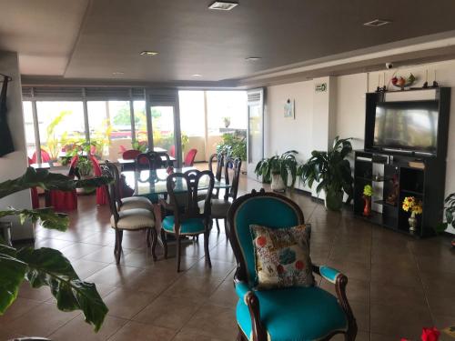 a dining room with a table and chairs and a tv at Hotel Bolivariano in Ibagué