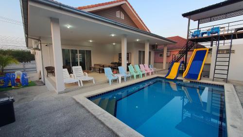 una piscina con sillas y una casa en Family POOL VILLA CHAAM, en Cha Am