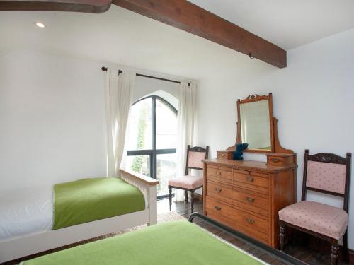 a bedroom with a bed and a mirror and a dresser at Chapel Cottage in Lydford