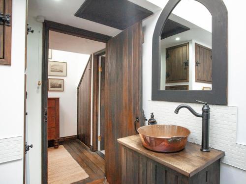 a bathroom with a copper sink and a mirror at Chapel Cottage in Lydford