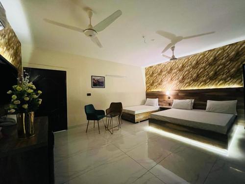 - une chambre avec un lit, un canapé et des chaises dans l'établissement TULIP HOTELS AND APPARTMENTS, à Karachi