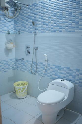 een badkamer met een wit toilet en een douche bij Vintage Villa in Alleppey