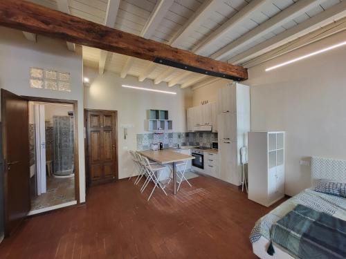 a kitchen and living room with a table and a bed at Mono Arnaldo in Brescia