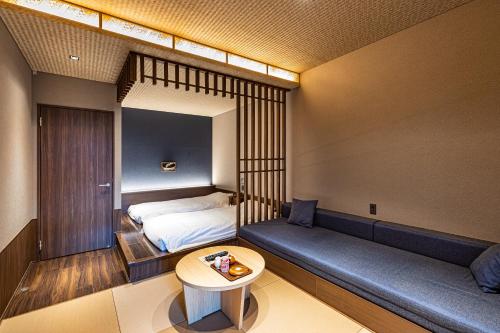 um pequeno quarto com uma cama e uma mesa em Susukinohara Ichinoyu em Hakone