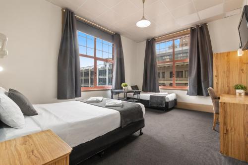 1 dormitorio con 1 cama, escritorio y ventanas en Adelaide Paringa, en Adelaida