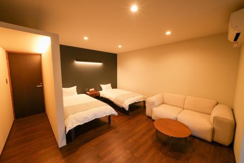 Habitación de hotel con 2 camas y sofá en ZENYA - Vacation STAY 89350v en Nakano