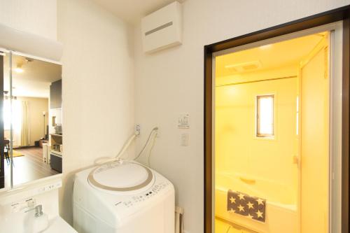 - une buanderie avec un lave-linge et un miroir dans l'établissement TY HOUSE 生野, à Osaka