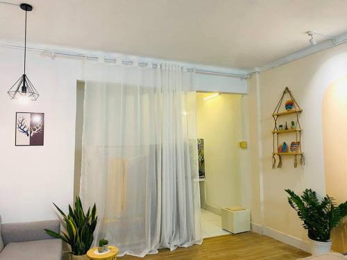 a living room with a white shower curtain at Studio Lagom 16, độc đáo và yên bình, kế bên dinh độc lập, nhà thờ Đức Bà ,đường Nguyễn du, phường Bến nghé, quận 1 in Ho Chi Minh City